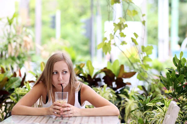 Молода жінка п'є каву в кафе на відкритому повітрі — стокове фото