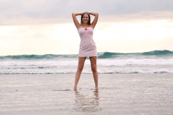 Молодая женщина стоит на пляже — стоковое фото