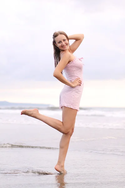 Junge Frau steht an einem Strand — Stockfoto
