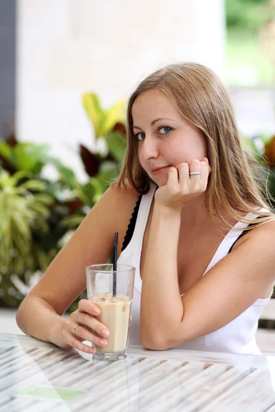 Nő egy kávézóban kávét iszik — Stock Fotó