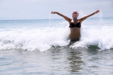 Beautiful woman bathes at ocean clipart