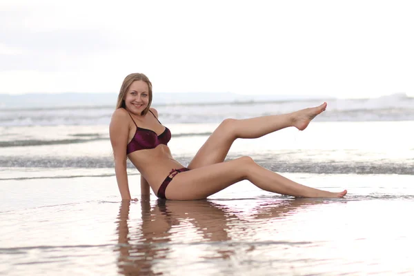 Mujer usando un bikini está de pie en la playa — Foto de Stock