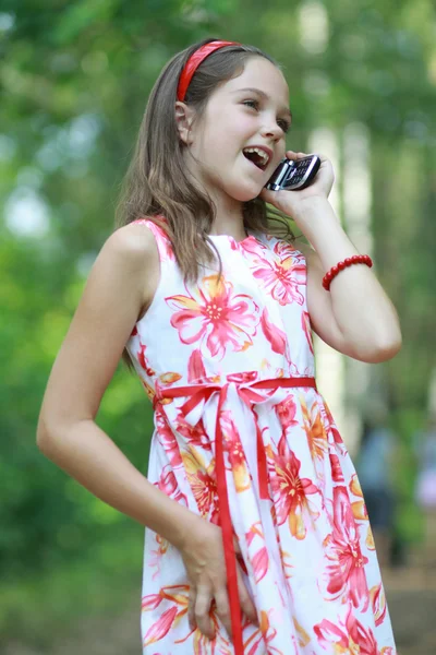 通过移动电话的小女孩会谈。 — 图库照片