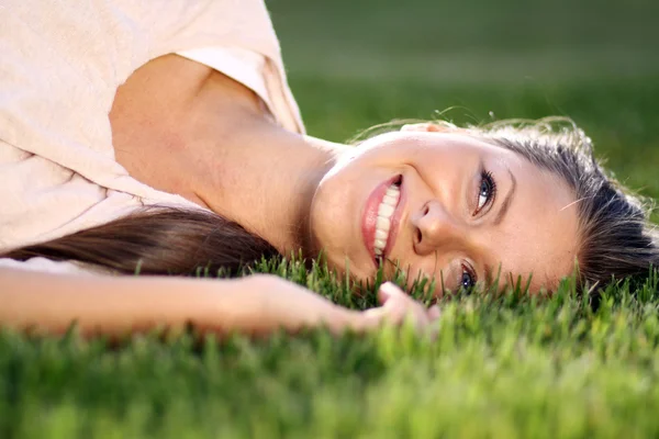 可爱的年轻女性 躺在公园草地上 — 图库照片