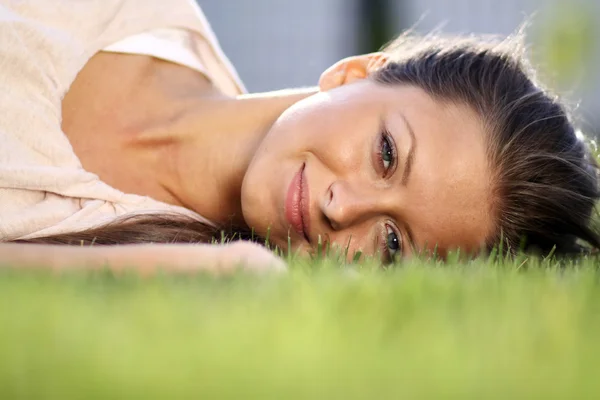 可爱的年轻女性 躺在公园草地上 — 图库照片
