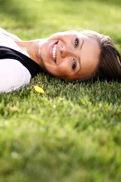 草のフィールド 公園で横になっているかわいい若い女性 — ストック写真