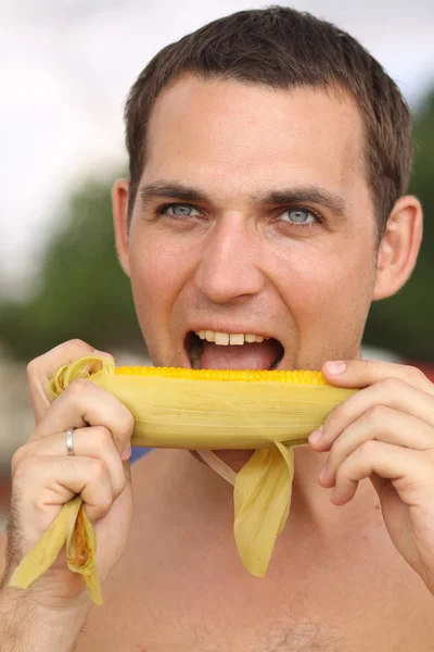 Young men eating hot corn — Stock Photo, Image