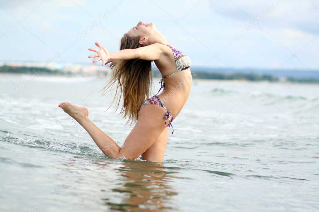 Beautiful woman bathes at ocean