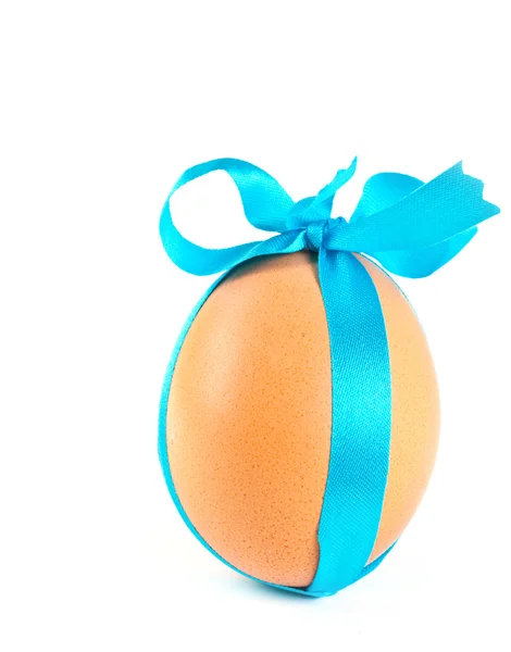 Пасхальное яйцо, украшенное голубой лентой — стоковое фото