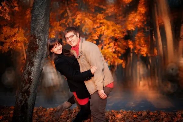 Молодая счастливая пара в осеннем парке — стоковое фото