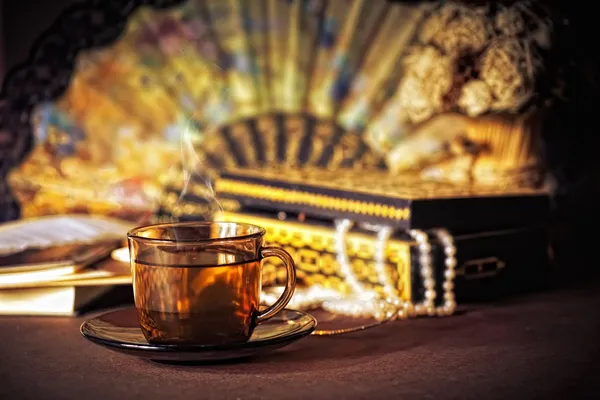 Stilleben med kopp te och kvinnors grejer — Stockfoto