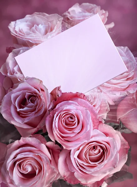 Um buquê de rosas rosa com um cartão de saudação — Fotografia de Stock