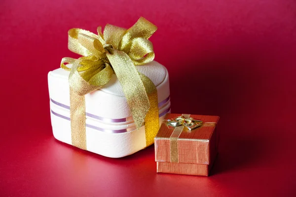Two boxes with ribbon on a red background — Stock Photo, Image