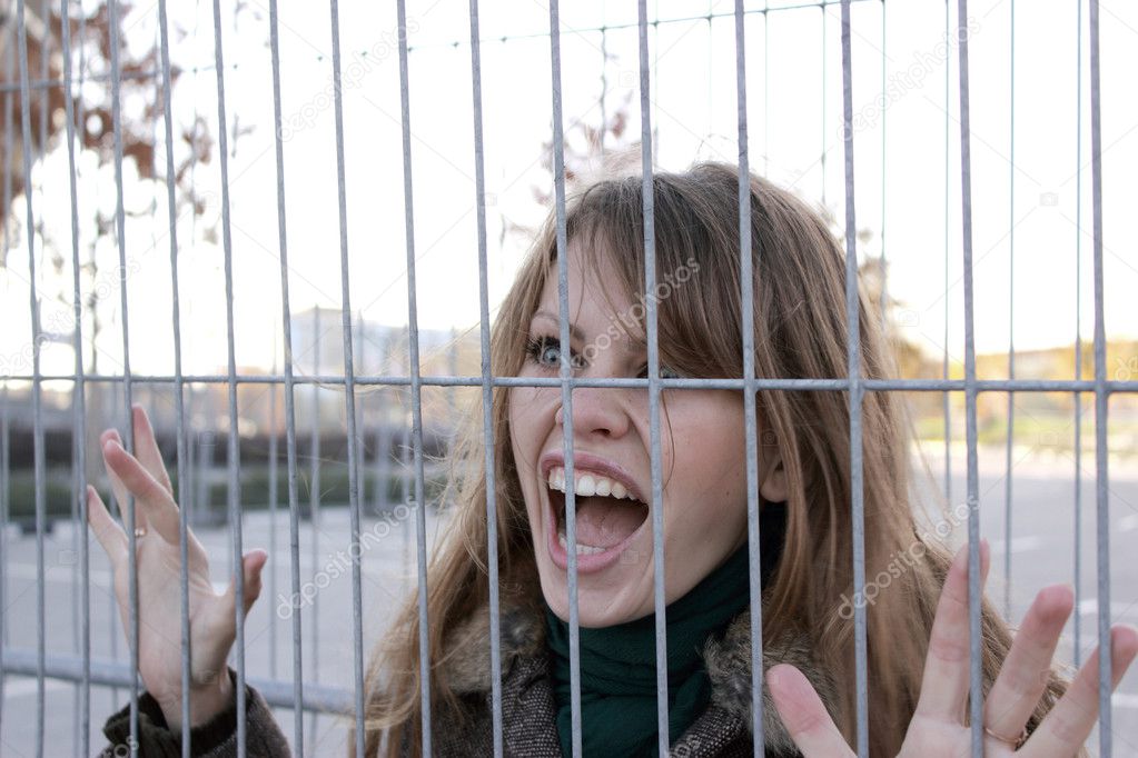 Girl very loud cries behind the iron bars