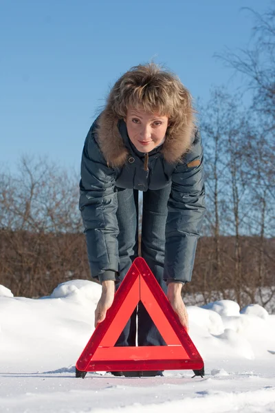 Mulher com um triângulo de aviso — Fotografia de Stock