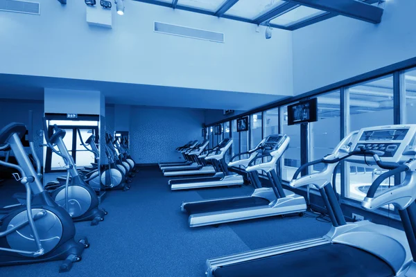 Row of jogging simulators in gym, monochromatic — Stock Photo, Image