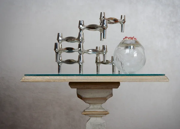 Stylish old-fashioned table with metal abstract sculpture and cr — Stock Photo, Image