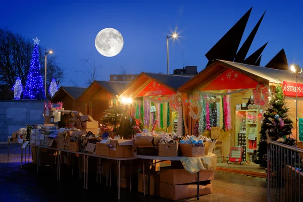 Mercado de Navidad con luna llena y árbol iluminado por la noche —  Fotos de Stock