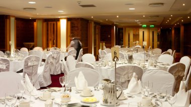 Hotel Hall interior with round tables set up for dinner clipart