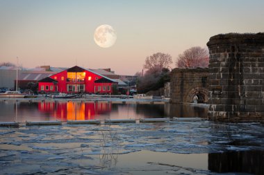 Full moon up on the rowing club and ice on Corrib river in cold winter morning clipart