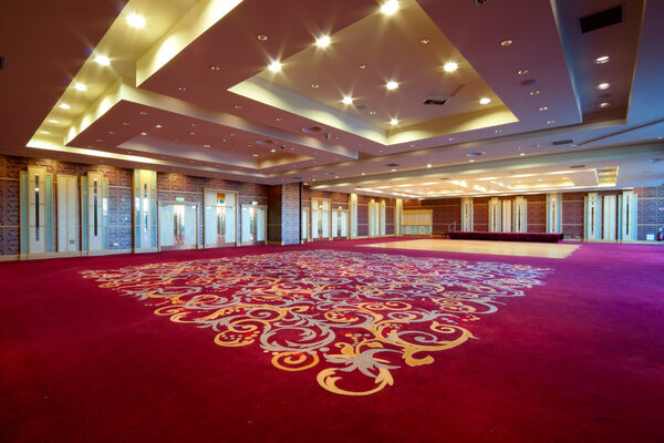 Огромный зал интерьера с красной ковровой дорожкой и герметизация с огнями в отеле
