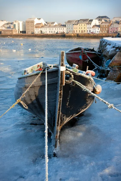 Boats covered by frost and ice on Corrib river in Claddagh, Galway