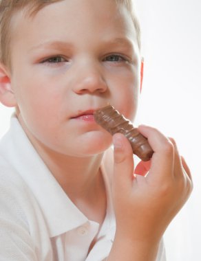 çikolata yiyen bir genç çocuk portresi,