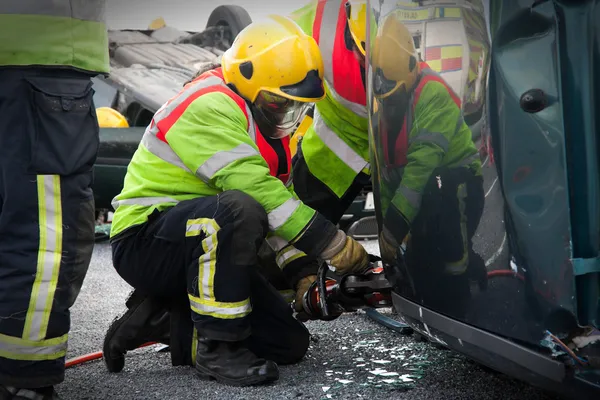 Fireman with Power Wedge at car crash — Stock Photo, Image