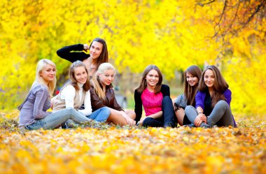 Many young girls in the autumn park clipart