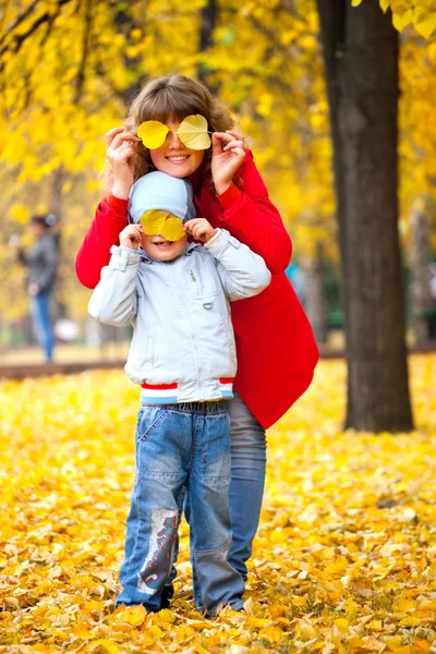 Criança e mãe com folhas de outono — Fotografia de Stock