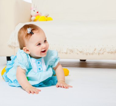 Sweet baby girl sitting on the floor clipart