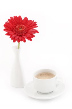 Flower in vase near caup of coffee clipart