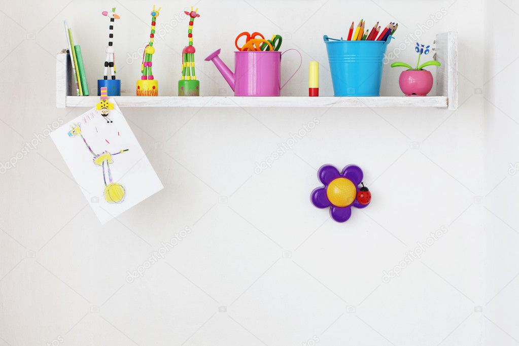 Kids shelf on white wall with toys on it