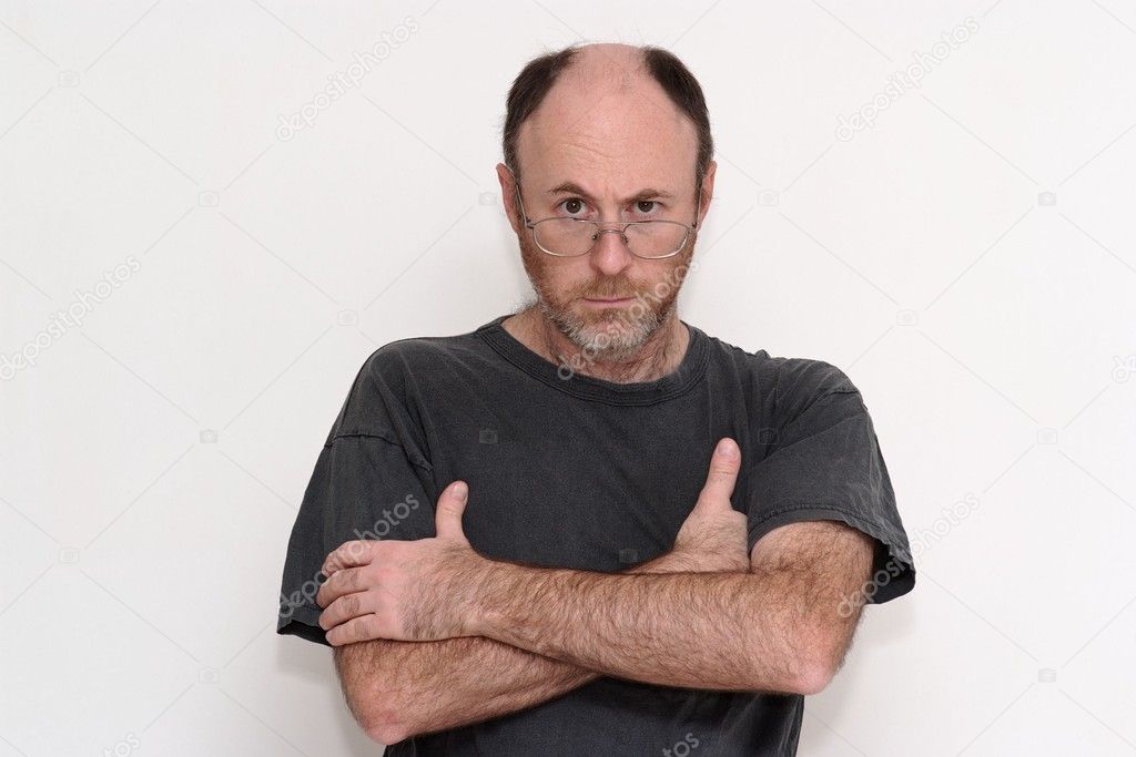 Unshaved disheveled man in spectacles frowning