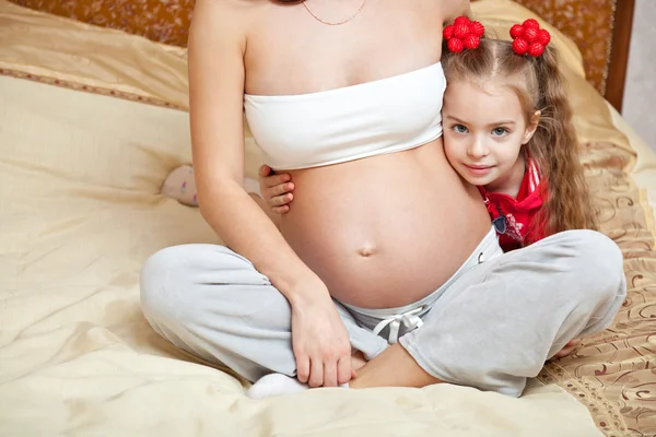 Ein Mädchen und ihre schwangere Mutter — Stockfoto