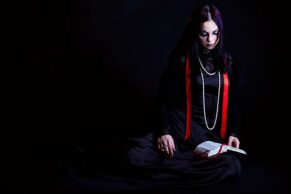 Een goth-meisje is het lezen van de Bijbel — Stockfoto