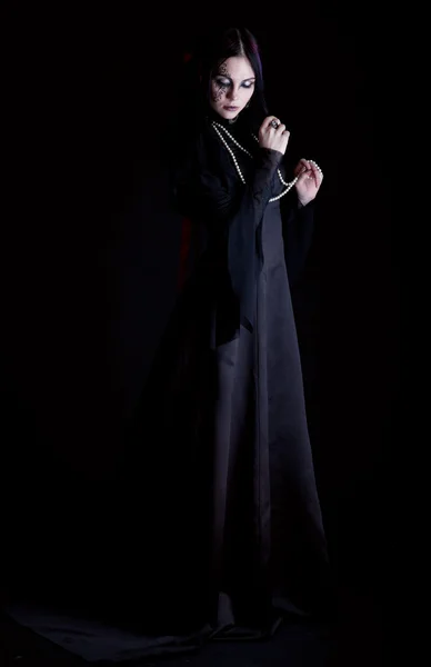 En goth-tjej håller ett kors — Stockfoto
