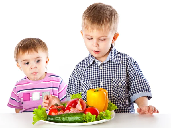 Boys and the plate of vegetables Royalty Free Stock Images