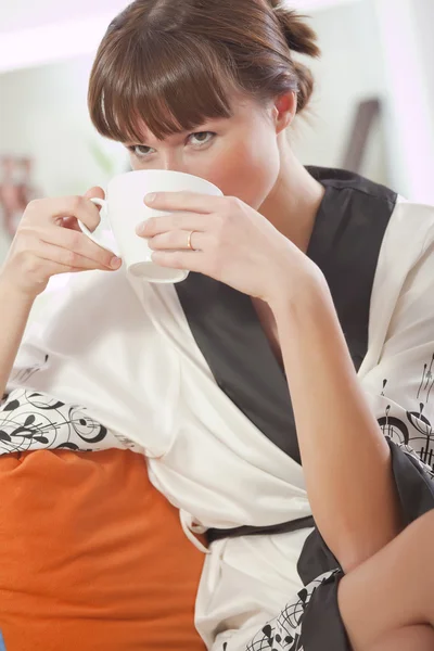 Vrouw in badjas het drinken van thee — Stockfoto