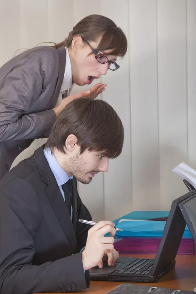 Женщина смотрит через плечо мужчины на компьютер — стоковое фото