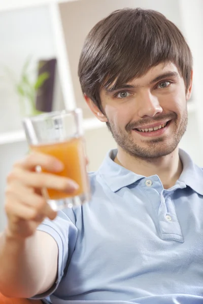 Άνθρωπος με γυαλί πορτοκαλί χυμό — Φωτογραφία Αρχείου