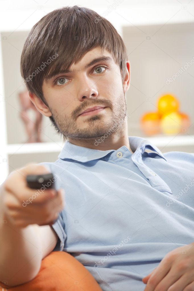 Man with television remote at home