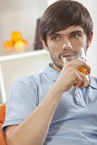 Людина п'є апельсиновий сік — стокове фото