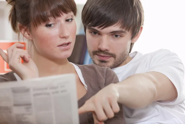 Young Couple Home Reading Newspaper Together — Stock Photo, Image