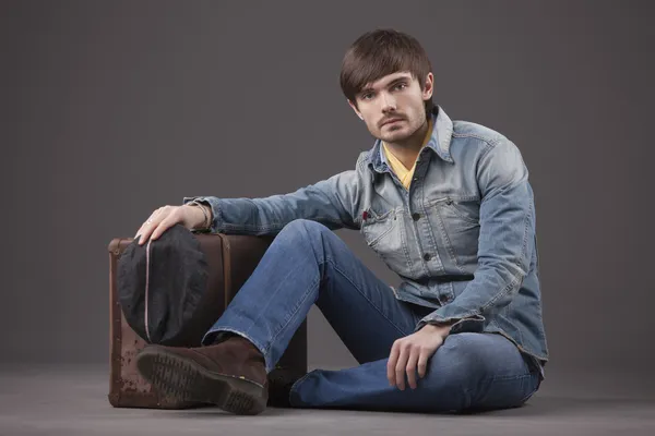 Mužský Model Džínové Oblečení Sedí Zemi Starý Kufr — Stock fotografie