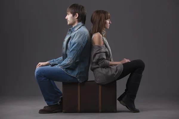 冲突中的关系 男人和女人坐在行李箱上背在背上 — 图库照片
