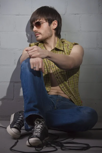 酷时尚男人在坐在砖墙上的复古太阳镜 — 图库照片
