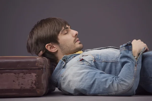 Мужчина отдыхает на чемодане — стоковое фото