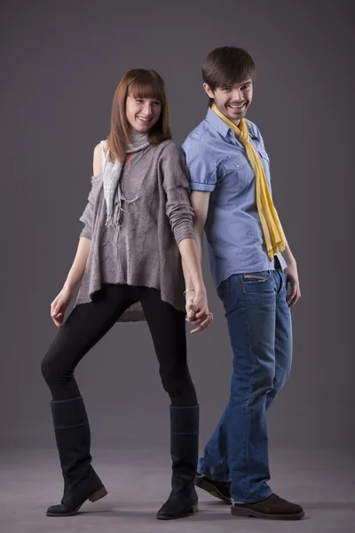 快乐时尚情侣摆在工作室在灰色背景 — 图库照片