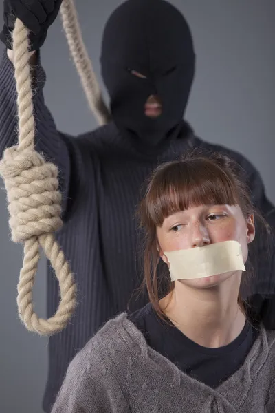 刽子手用绳套和女性受害者在灰色背景 — 图库照片